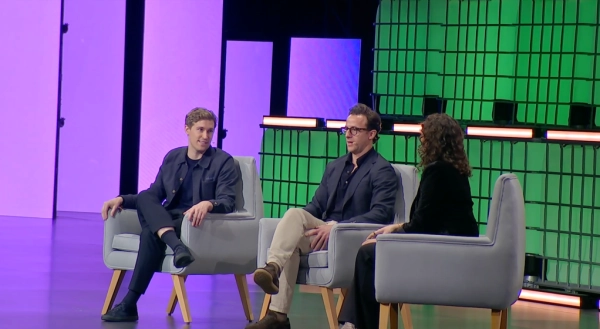 Трое людей на сцене участвуют в обсуждении на конференции.