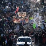 Большая уличная демонстрация с плакатами и пророй людей, протестующих за права в городе.