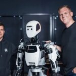 Два человека рядом с гуманоидным роботом в помещении.