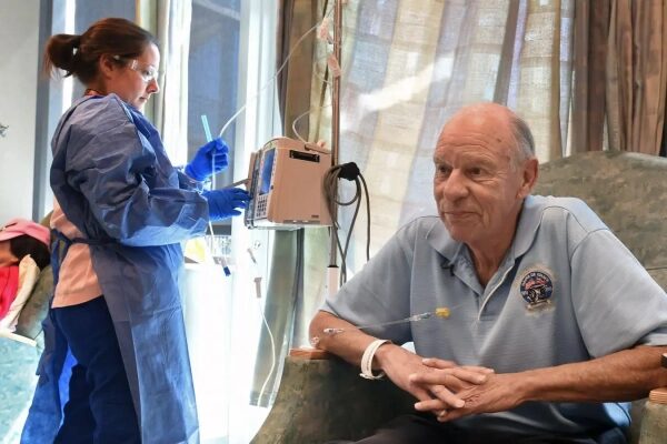 Медсестра ухаживает за пациентом в больнице, проводит медицинскую процедуру.