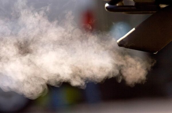 Одним махом Трамп отменил американские правила регулирования выбросов парниковых газов. 3 Выхлопные газы автомобиля на фоне размытых объектов, загрязнение воздуха.