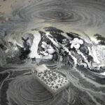 Черно-белый интерьер комнаты с абстрактными узорами и кроватью в центре.