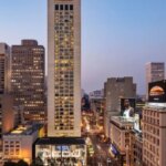 Вид на городской пейзаж высотками и вечерним освещением города.