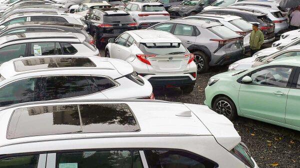 Парковка с множеством разноцветных автомобилей в плотных рядах.