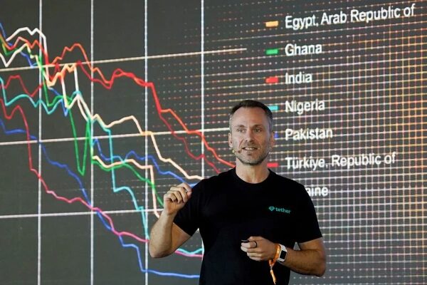 Человек на фоне графиков экономических показателей разных стран.