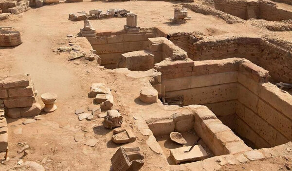 Археологические раскопки древнего сооружения, остатки колонн и стен.