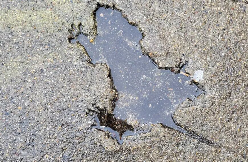 Лужа в асфальте в форме карты Италии на грубой поверхности.