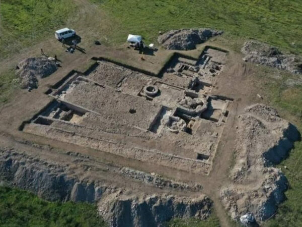 Археологические раскопки древнего сооружения с участием людей и техники.