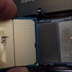 Процессор с погнутыми ножками на фоне материнской платы.