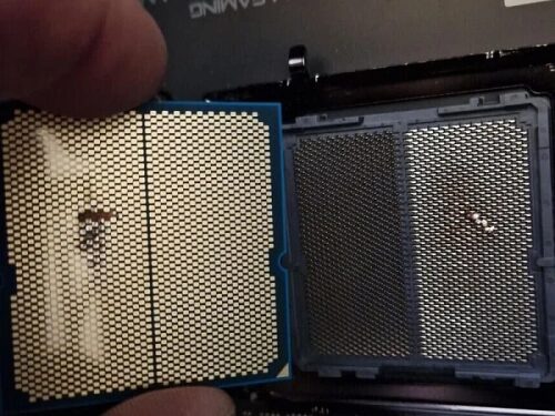 Процессор с погнутыми ножками на фоне материнской платы.