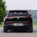 Вид сзади электрического SUV Fisker Ocean на фоне природы.