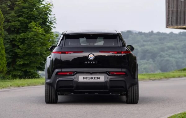 Вид сзади электрического SUV Fisker Ocean на фоне природы.