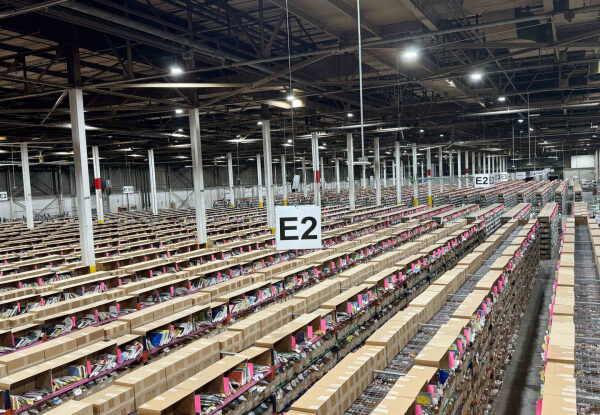 Склад с продукцией и рядами стеллажей внутри крупного промышленного помещения.