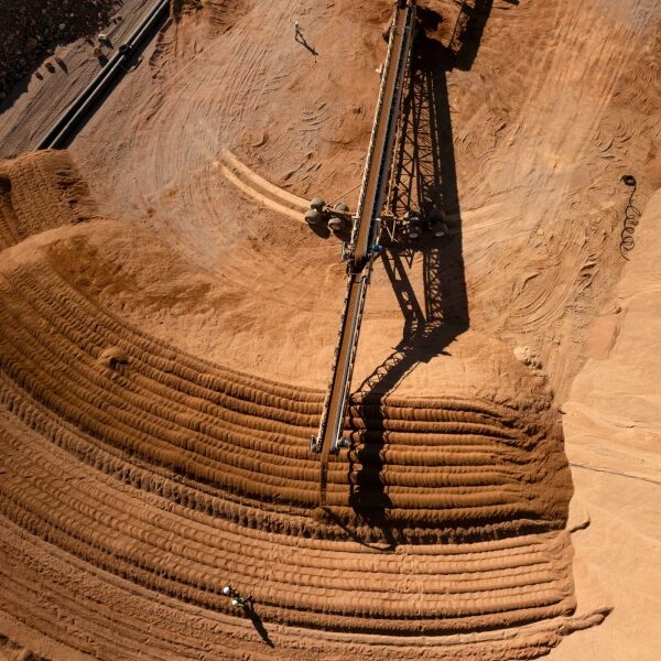 Микроорганизмы могут добывать металл, необходимый для экологически чистых технологий. 3 Над насыпью красной земли зависает большой агрегат.