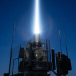 Лазерная установка излучает мощный луч в ночное небо.