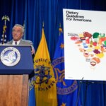 Презентация американских диетических рекомендаций на фоне государственных флагов.