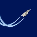 Купюра в виде самолёта летит по небу, оставляя следы.