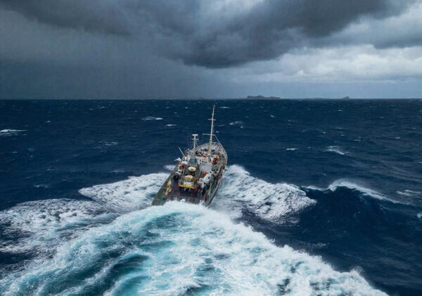 Корабль в бурном море под грозовым небом.