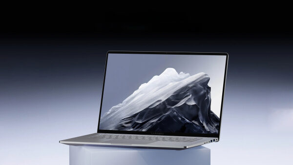 Ноутбук Lenovo с изображением горы на экране, вид сбоку, серый фон.