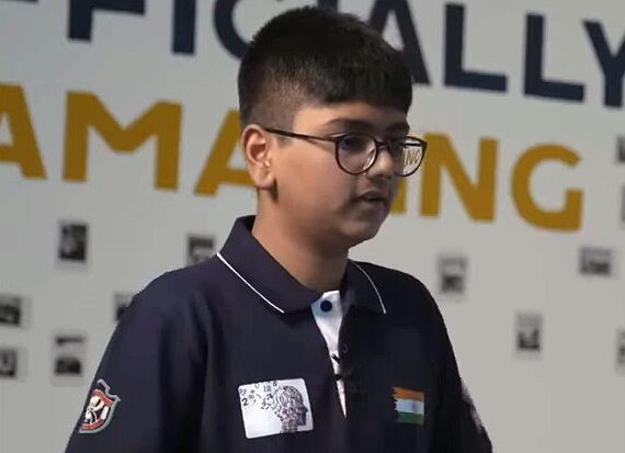 Подросток в темной футболке с индийским флагом на фоне надписи.