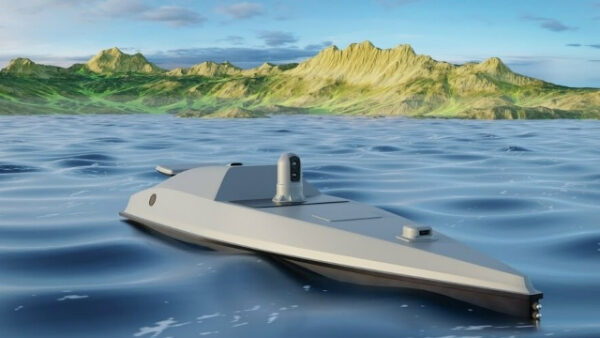 Беспилотный корабль в море, на фоне зеленых гор и облачного неба.