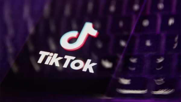 Логотип TikTok на фоне клавиатуры, фокус на бренде, фиолетовые оттенки.