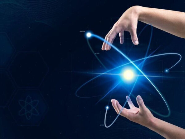 Руки вокруг светящегося атома на темном фоне. Наука и технологии.