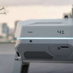 Станция зарядки дрона Skydio и летающий дрон на фоне городской панорамы.