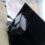 Уличная камера с солнечной панелью, закрепленная на столбе.