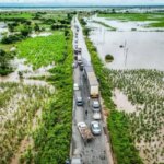 Шоссе среди затопленных полей, машины в пробке из-за наводнения.