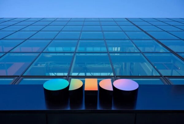 Современное стеклянное здание с ярким логотипом на фасаде.