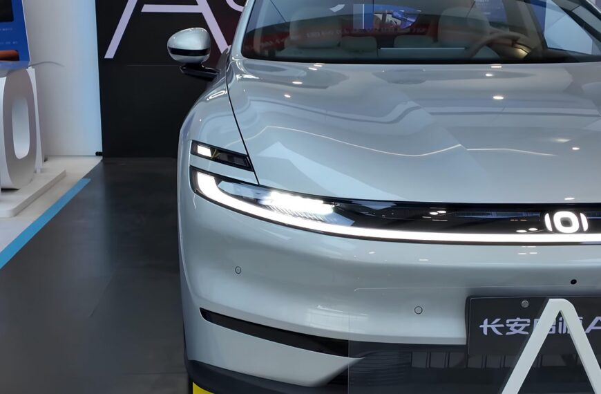 Белый электромобиль на выставке, вид спереди, дизайн фар и передней панели.