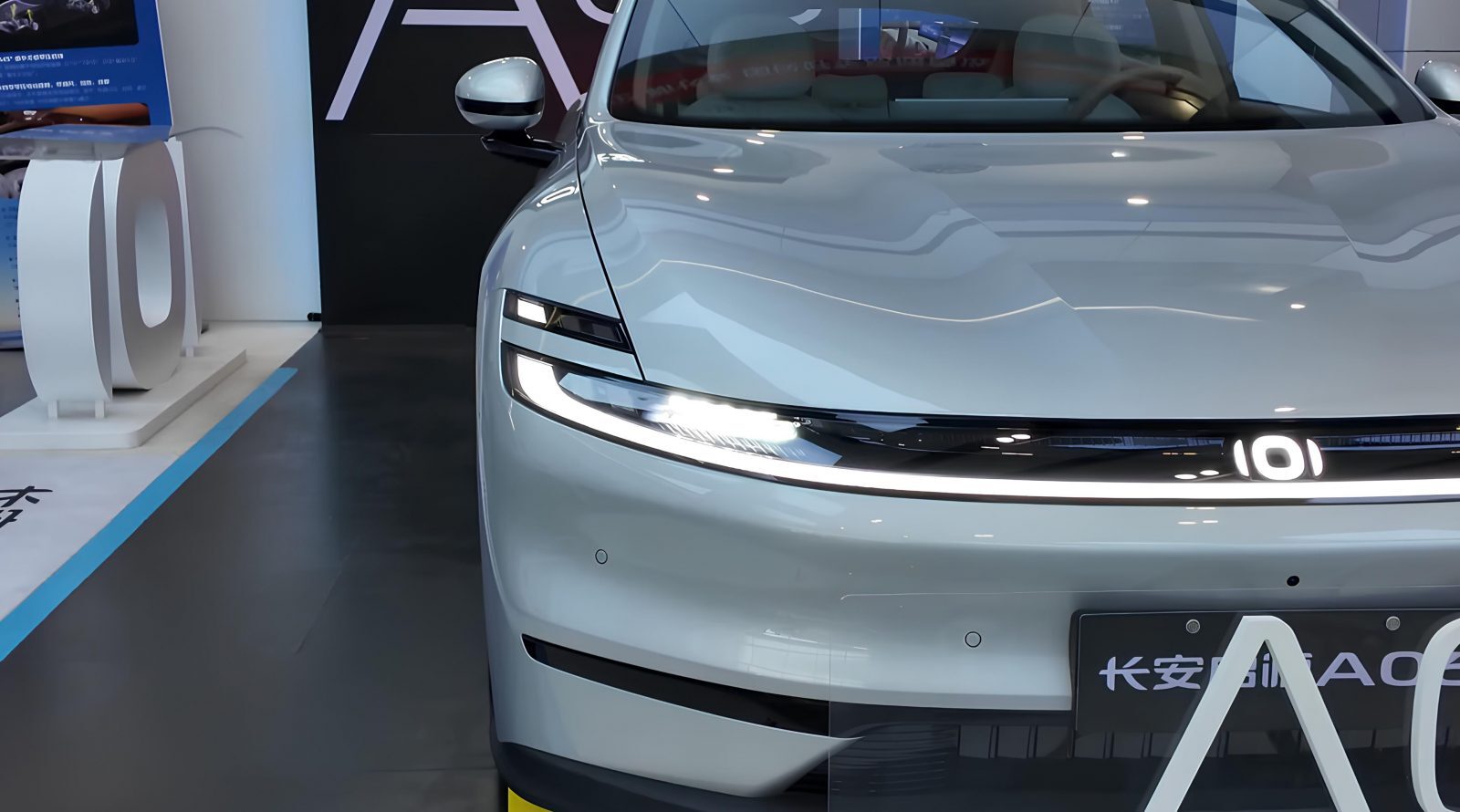 Электромобиль, которому не страшны −40 градусов 3 Белый электромобиль на выставке, вид спереди, дизайн фар и передней панели.