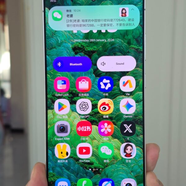 Смартфон с открытым экраном и приложениями на зеленом фоне, время 28 января 2026.