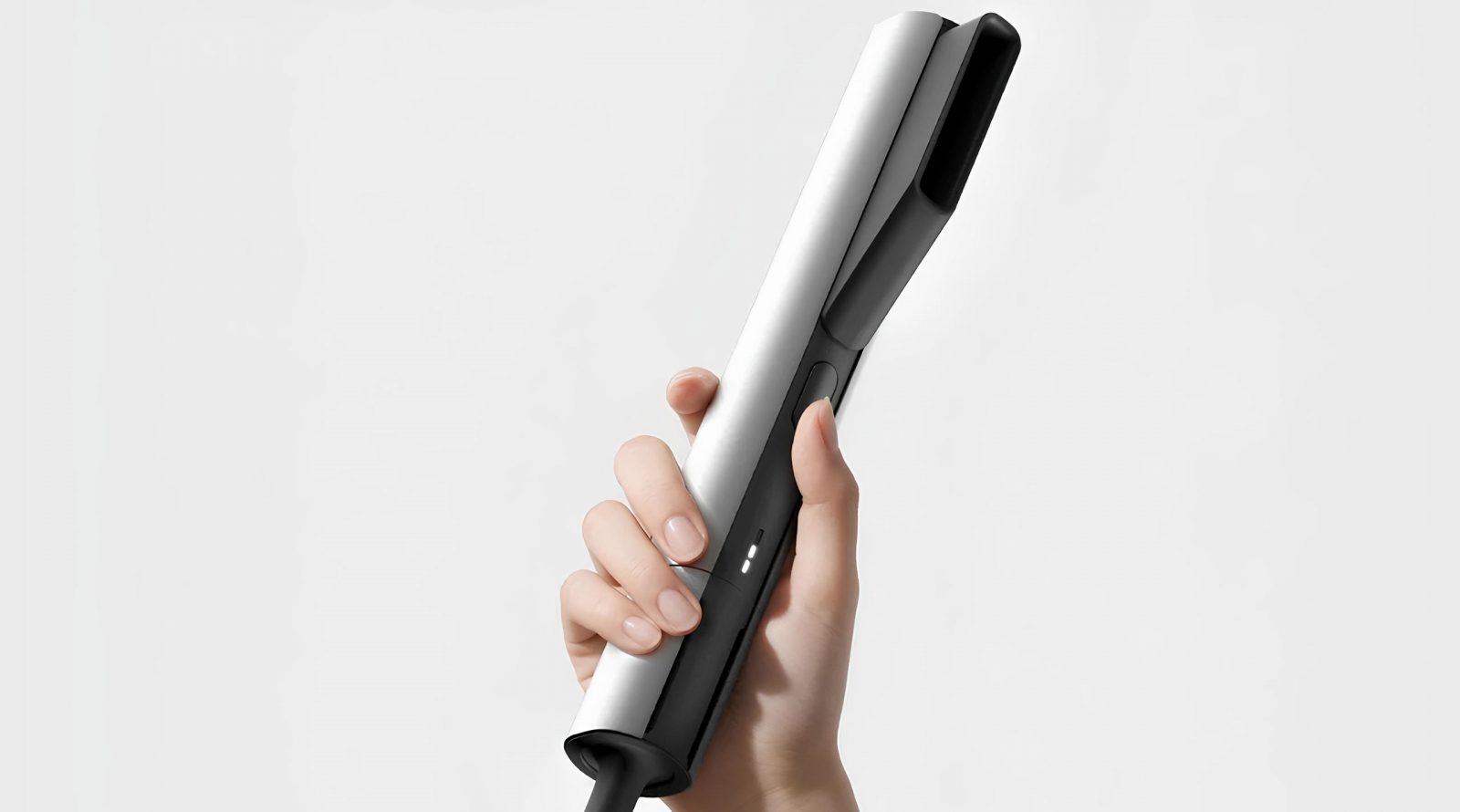 FloX переосмысливает привычный выпрямитель для волос 3 Рука держит черно-белый выпрямитель для волос на белом фоне.