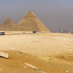 Пирамиды Гизы на фоне пустыни и туристических автобусов, Египет.