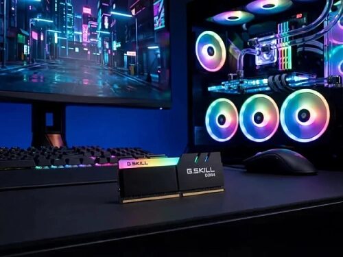 Игровой компьютер с подсветкой, монитор, оперативная память G.Skill на столе.