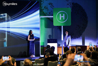 Презентация компании Hoymiles: выступление перед аудиторией на фоне логотипа.