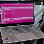 Ноутбук MSI на фоне серверов с открытым терминалом в операционной системе Linux.