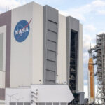 Здание NASA и ракета на стартовой площадке, подготовка космической миссии.