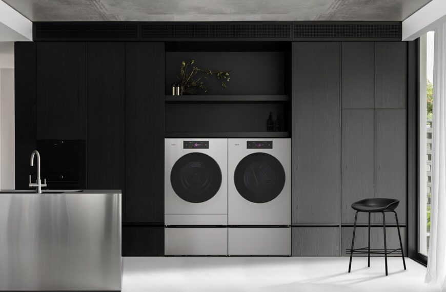 Современная кухня с черными шкафами, стирочной техникой и металлическим островом.