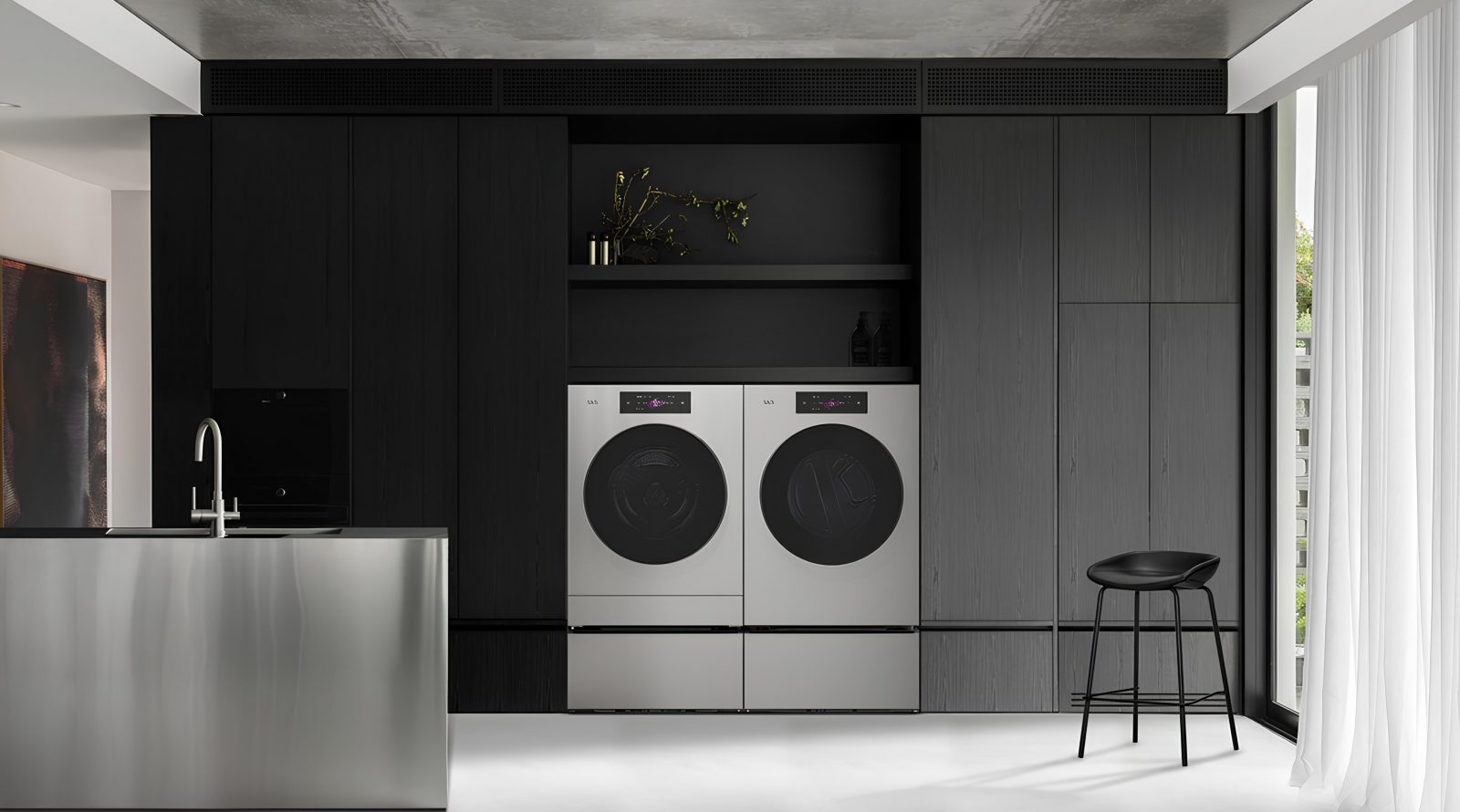 Современная кухня с черными шкафами, стирочной техникой и металлическим островом.