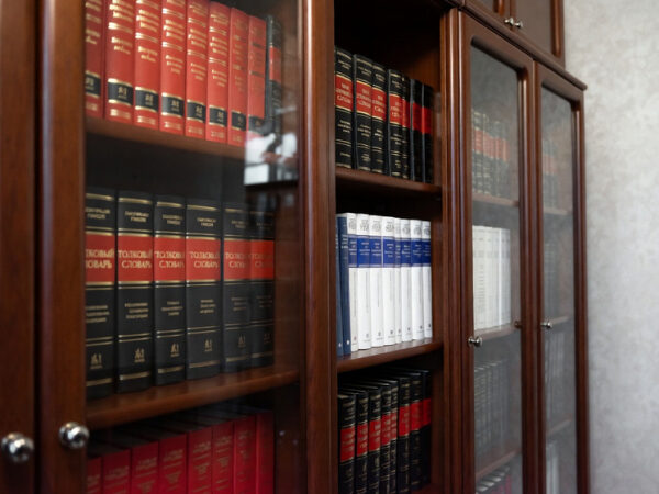 Полки с толковыми словарями в деревянном книжном шкафу, часть домашней библиотеки.