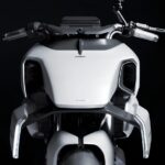 Белый футуристичный мотоцикл на черном фоне, вид спереди.