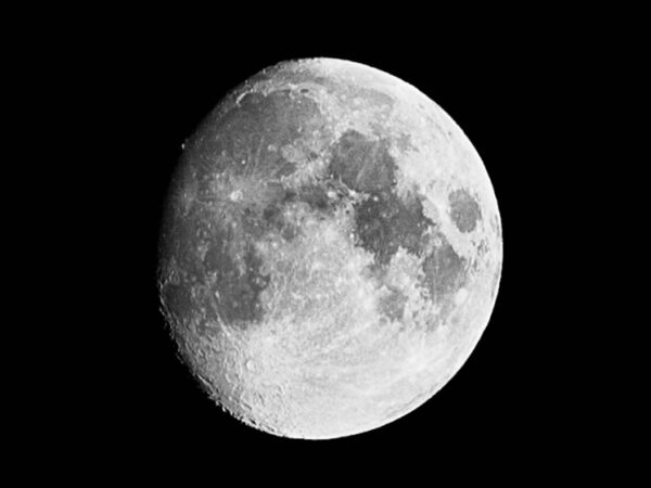 Чёрно-белое изображение Луны на фоне ночного неба.