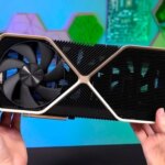 Видеокарта в руках на фоне технологий, крупный план вентилятора и радиатора.