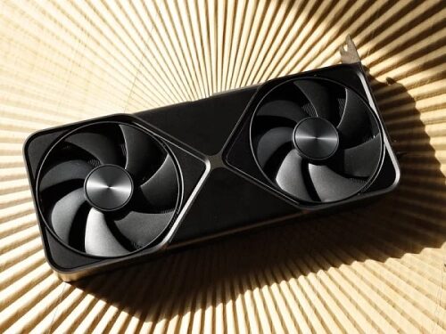 Видеокарта с двумя вентиляторами на фоне светлой поверхности.