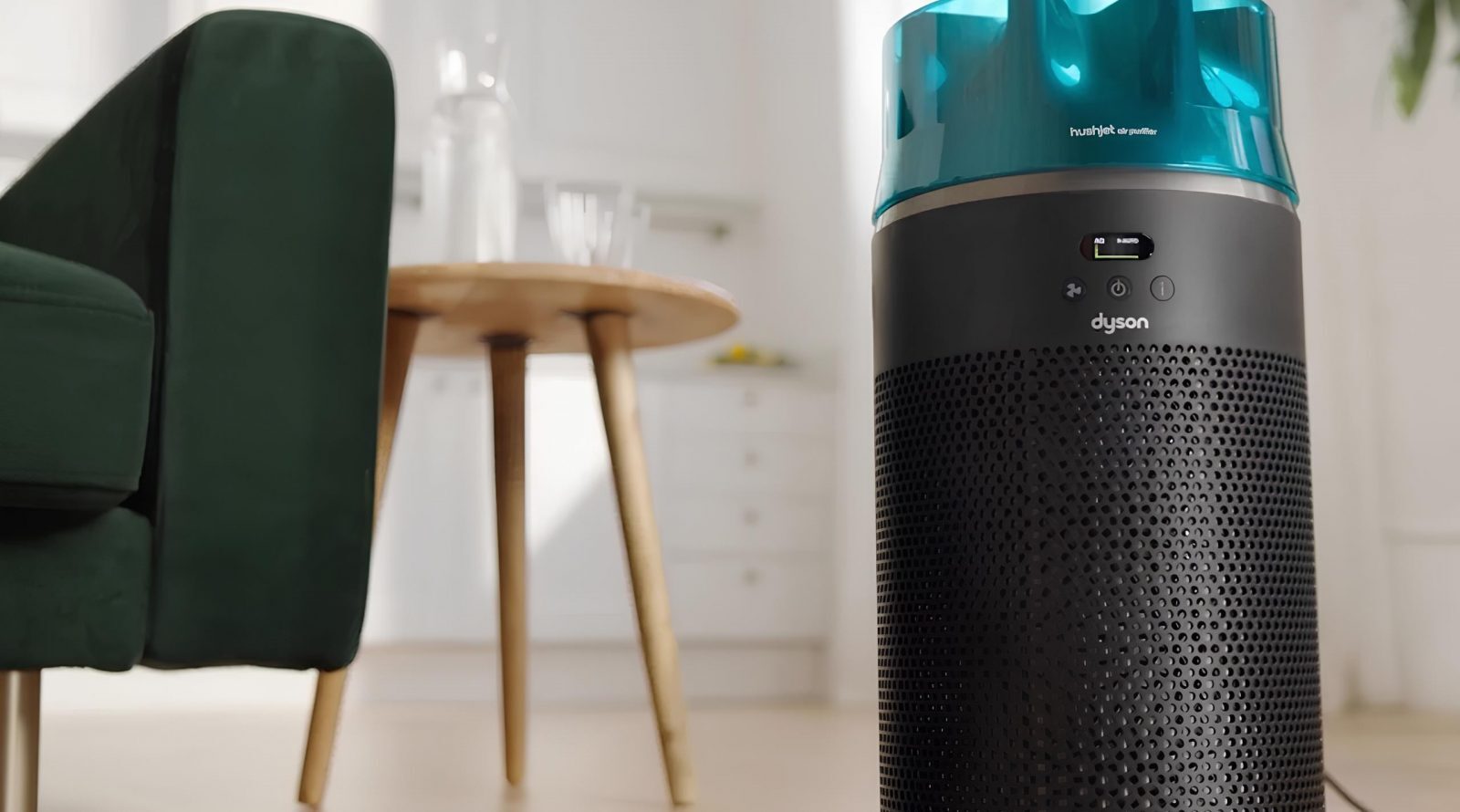 Очиститель воздуха Dyson HushJet с авиационными корнями 2 Очиститель воздуха в интерьере комнаты, рядом зелёный диван и деревянный стол.