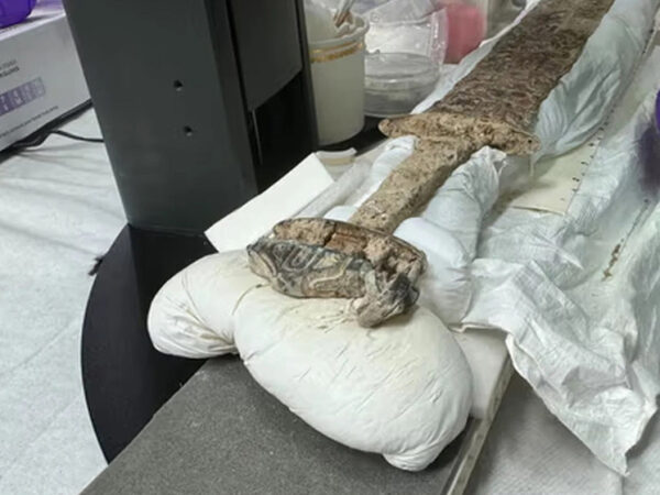 Старинный меч на столе в лаборатории во время процесса реставрации.