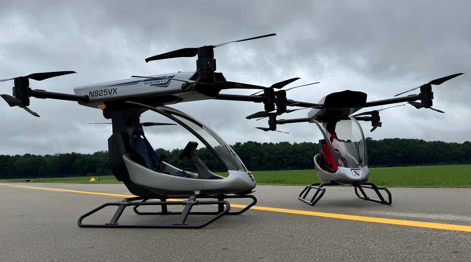 Персональный летающий транспорт будущего Velociter X-1 1 Два футуристических эйр-мобиля на взлетной полосе в облачную погоду.